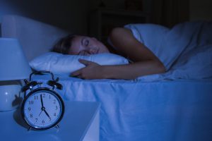 A woman sleeping in a dark room. 