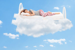 A woman sleeps peacefully on a cloud.