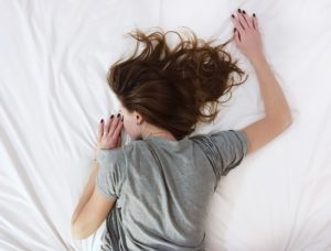 a woman sleeps on a new mattress to relieve back pain while sleeping